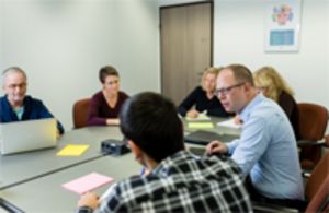 Der sehbehinderte Sandro Lüthi bei einer Teamsitzung mit seinen Kolleginnen und Kollegen am Konferenztisch. Bild: SZB