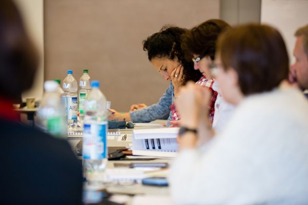 Teilnehmerinnen eines Kurses sitzen an einem Tisch und studieren ihre Unterlagen. Bild: SZBLIND