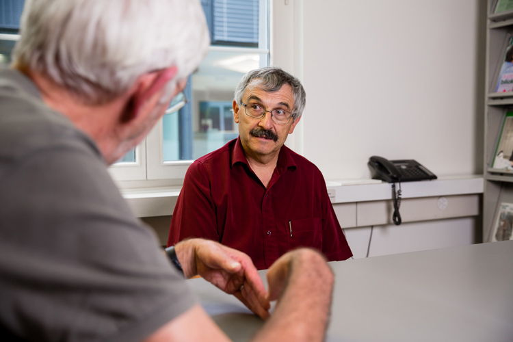 Ein Beratungsgespräch: Der Sozialarbeiter informiert einen sehbehinderten Mann über seine Möglichkeiten. Bild: SZBLIND